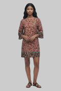 Woman wearing a patterned dress on a white background
