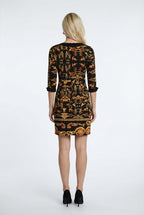 Woman wearing a black and orange patterned dress on a white background