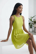 Woman wearing a bright yellow dress sitting on a white surface with a white background